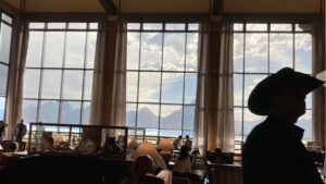 An attendee of the 2024 Jackson Hole Economic Policy Symposium stands in the Jackson Lake Lodge, donning a cowboy hat.