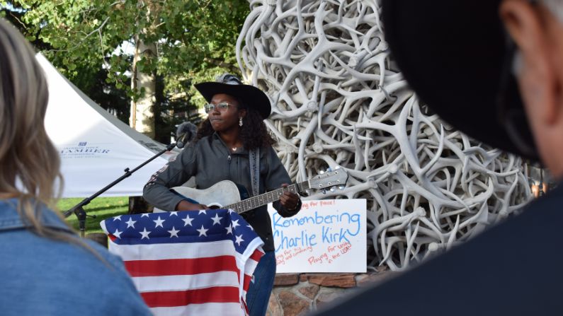 Bea Jones plays for a small crowd on Jackson’s Town Square hours after the news broke that Charlie Kirk had been fatally shot. Jones, a conservative, organized the vigil not as a political space but to “grieve, remember, and stand together in unity.” (Sophia Boyd-Fliegel / KHOL)