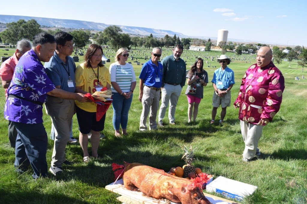 Arvin Chin, left, participates in a traditional blessing of the ancestors at the Chinese section of the Rock Springs cemetery. To his right, Ricky and Grace Leo join the ritual. 